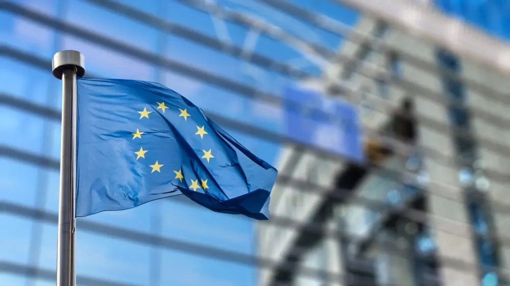 European Union flag flying in front of the European Union Parliament building